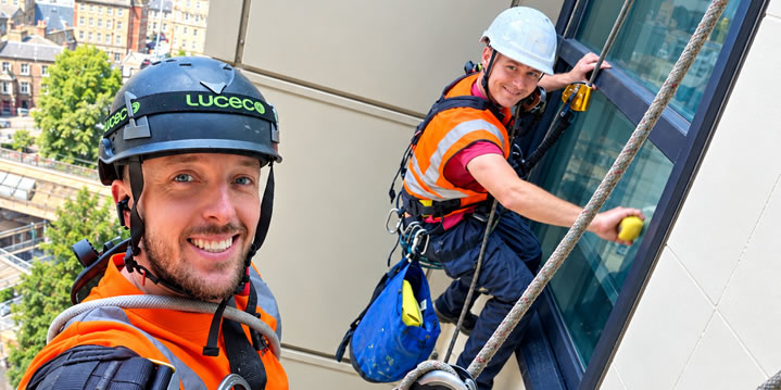 Technicians working on external windows by rope access