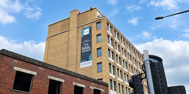 Printed signage high on The Sails Works above the building in front