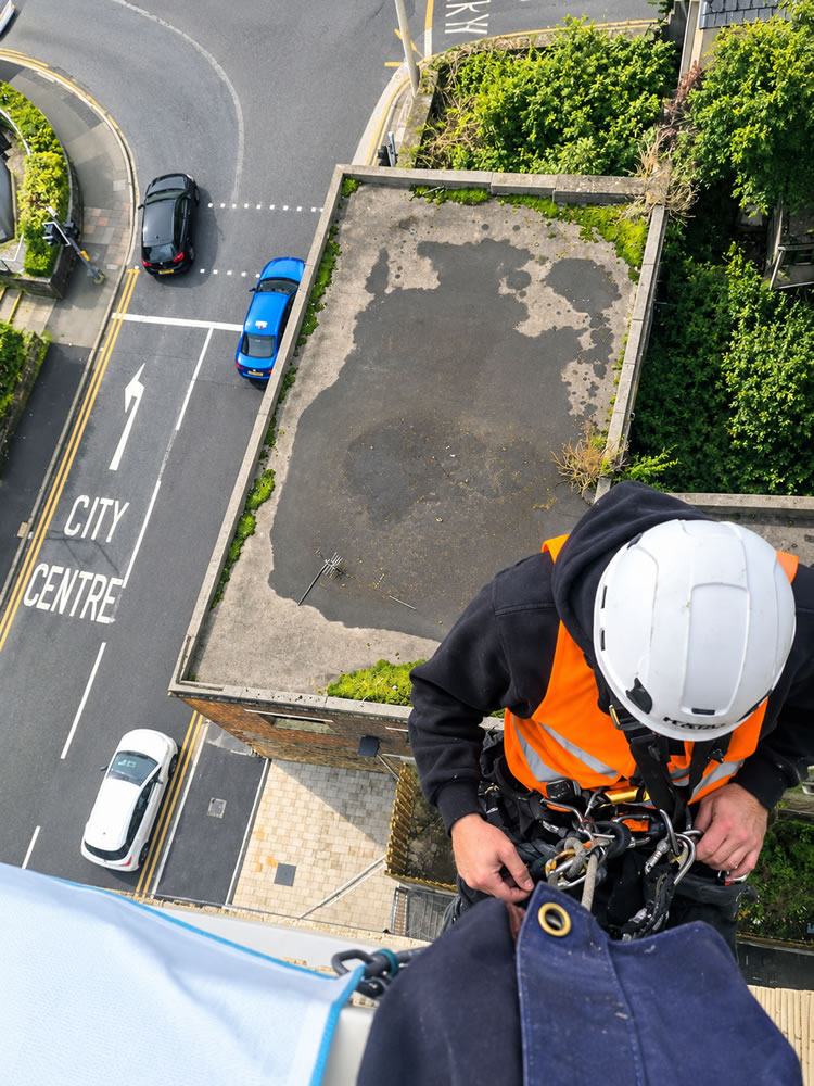 The Sails Works elevation with signage and a rope access technician above the lower building