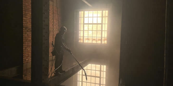 Rope access technician jet washing inside the Tyne Bridge North Tower
